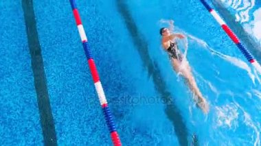 Uzak sporcu bir yüzme havuzunda yüzüyor. Üstten Görünüm.