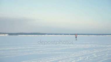 Uzaktan bir donmuş nehir üzerinde koşan bir çıplak göğüslü adam silüeti. 4k.