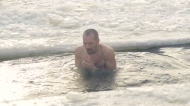 Sakallı bir adam buz gibi soğuk su altında dips.