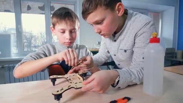 Dois rapazes jovens engenheiros a fazer modelos de drones. 4K . — Vídeo de Stock