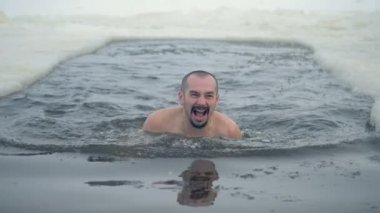 Bir adam bir buz delik yüzüyor ve dışarı çıkmak anlamına gelir.