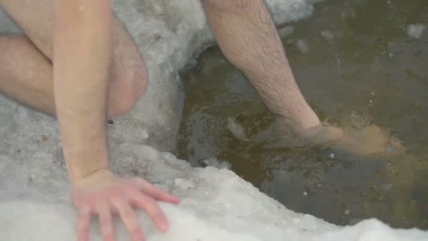 Pernas masculinas gingerly entrar água buraco de gelo . — Vídeo de Stock