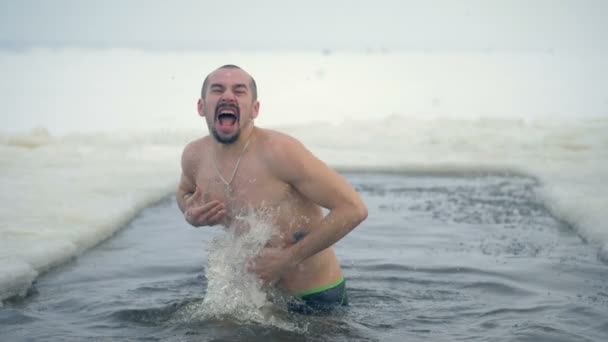 Un hombre grita y salpica agua sobre sí mismo . — Vídeos de Stock
