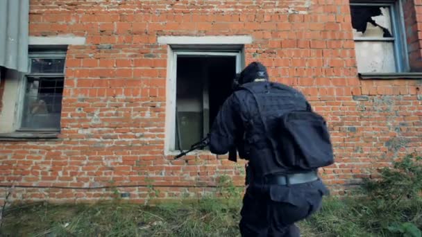 Two SWAT solders jump run and jump inside a rundown building. — Stock Video