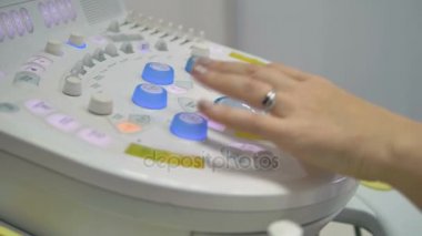 Bir doktor bir ultrason makine kontrol paneli kullanır.
