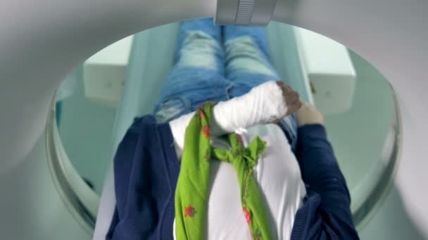 Een jongen met een gebroken arm inters een Ct-scanner. — Stockvideo