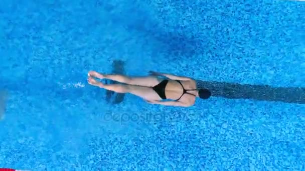 Uma nadadora usa as pernas para nadar debaixo de água . — Vídeo de Stock