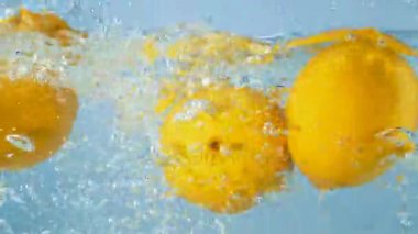 Su bir sıçrama ile üç taze sarı limon düşmek.