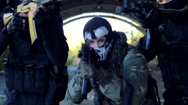 Three masked officers walk with barrels of their rifles on hiding enemy. — Stock Video