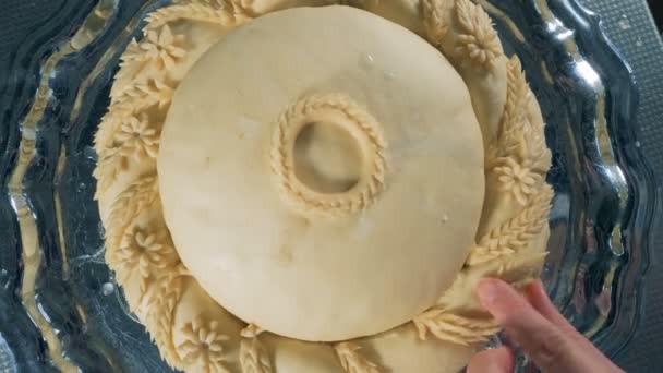 An unbaked round bread during decoration in a close view. — Stock Video