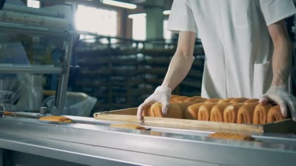 Un operador con un uniforme blanco trabaja en una envoltura de pastelería de película . — Vídeo de stock