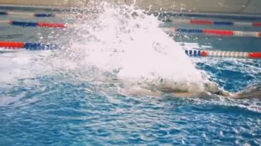Güçlü yüzücüler silah kelebek vuruş sırasında ağır çekimde.