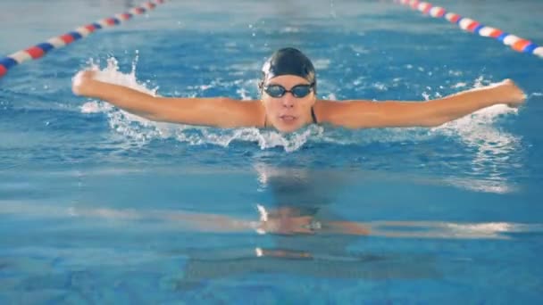 Kadın bir yüzücü bir yavaş hareket kelebek suya rahatsız ediyor.. — Stok video
