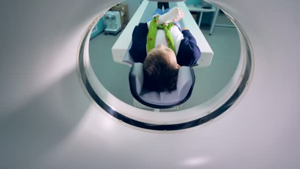Um rapaz está a entrar num tomógrafo de ressonância magnética. — Vídeo de Stock