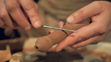 Bir metal çubukla parlatma sırasında kil kaşık. 