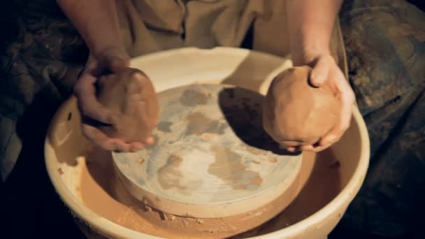 Een pottenbakker verenigt twee klontjes van klei. — Stockvideo