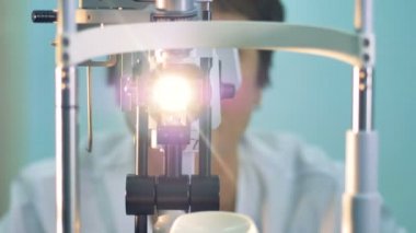 Doktor görme muayene için bir makine hareket ediyor