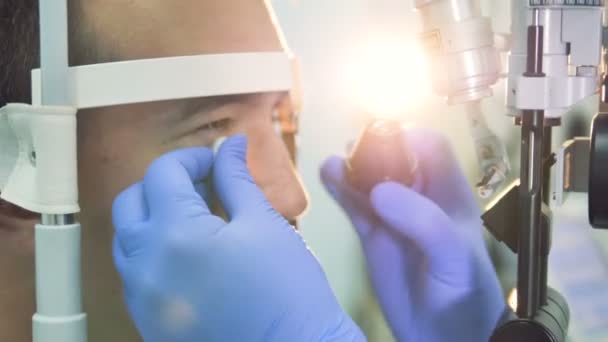 Крупним планом чоловіче око оглядається лікарями руками і окулярами — стокове відео