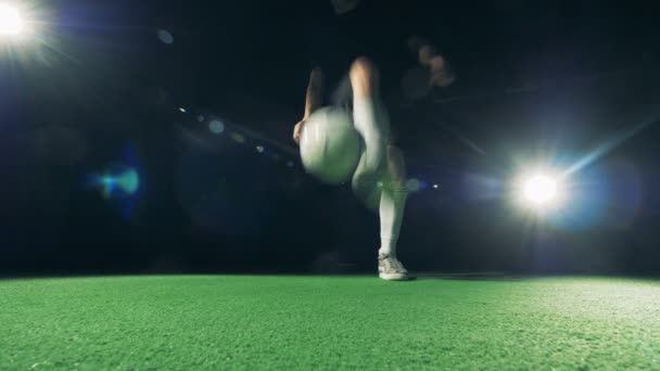 Professional soccer player is juggling and making tricks, view from below. 