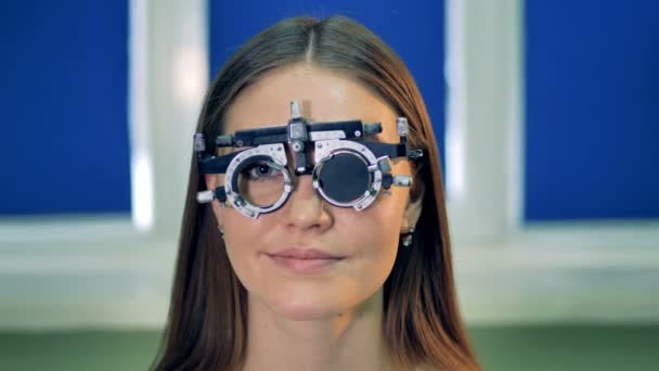 Una mujer en la montura de prueba asiente después de insertar las lentes de prueba . — Vídeos de Stock
