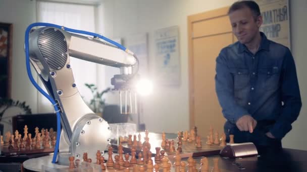 Robot hand manipulator moves the chess figure. Futuristic concept. Playing chess with a man. — Stock Video