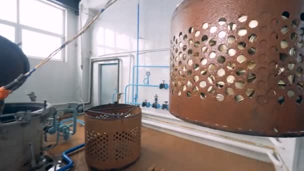 Worker move tin cans from water to wooden pallets using hydraulic manipulator. — Stock Video