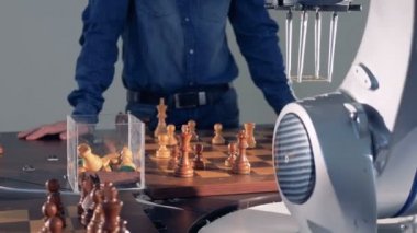 Robot ve insan rekabet. Robot el bir adamla satranç oynuyor. Yapay zeka kavramı. 4k.