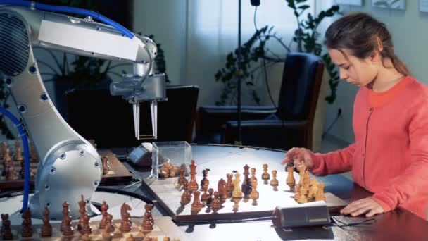 Chica joven se mueve figura de ajedrez jugando con un robot de ajedrez automatizado moderno. 4K . — Vídeo de stock