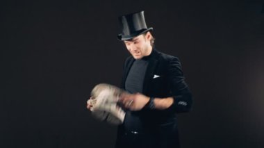Erkek bir sihirbaz kartlarla oyun oynuyor ve onları bir şapka dönüştürme