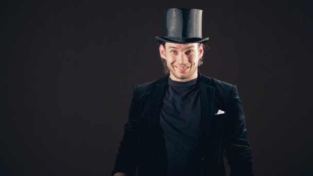 Een illusionist vertoont een goocheltruc met een sprankelende balletje — Stockvideo