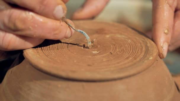 Детальний вигляд на гончарі, який вирізає свій підпис на нижній поверхні чаші . — стокове відео