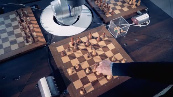 Brazos humanos y robóticos mueven piezas de ajedrez mientras juegan — Vídeos de Stock