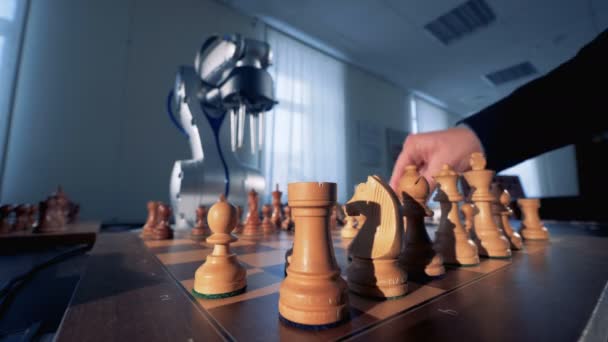 Zblízka šachové figurky přesouvány lidská ruka a robotické rameno — Stock video