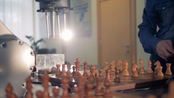 Робот і дорослий чоловік обмінюються шаховими фігурами під час гри — стокове відео