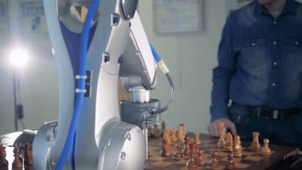 An adult man and a robot are playing chess and capturing each others pieces — Stock Video