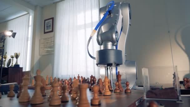 Close up of a robotic arm and a human hand relocating chess pieces — Stock Video