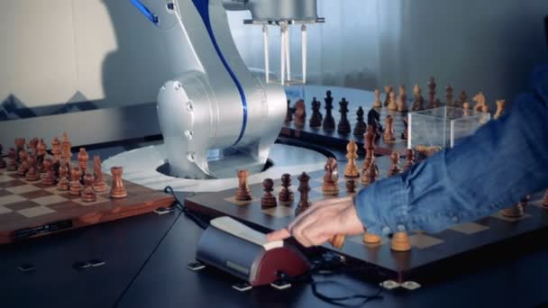 A robot and a man are capturing each others chess pieces while playing — Stock Video