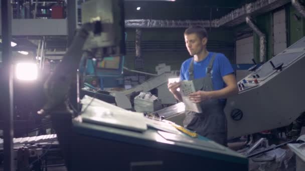 Працівник перевіряє свіжі друкована газета в друкарні обладнання. — стокове відео