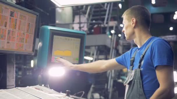 Працівник за допомогою сенсорного екрана, що діють індустріальна машина. — стокове відео