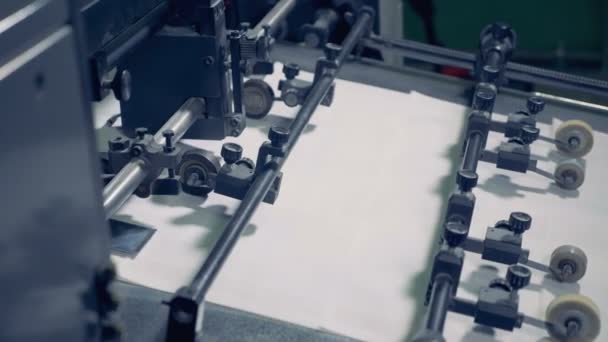 Gros plan des éléments des machines industrielles stabilisant les morceaux de papier pendant leur mouvement — Video