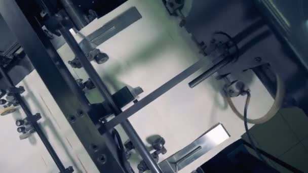 Ovanifrån av en verktygsmaskin som flyttar flera bitar av papper en — Stockvideo