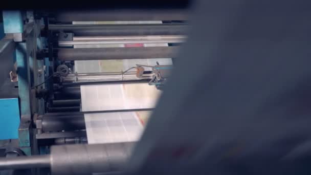 Printed newspapers rolling on printing equipment. — Stock Video