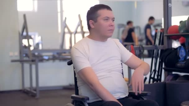 A disabled man is stretching his arms and shoulders while sitting in a wheelchair — Stock Video