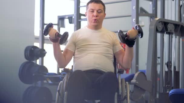 Beelden van een sportschool faciliteit met een gehandicapte man uitoefenen in het — Stockvideo