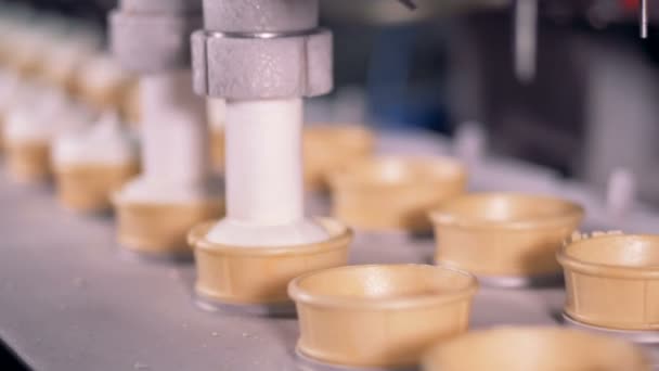 Copos Wafer estão sendo preenchidos com pasta de sorvete por uma máquina de fábrica — Vídeo de Stock