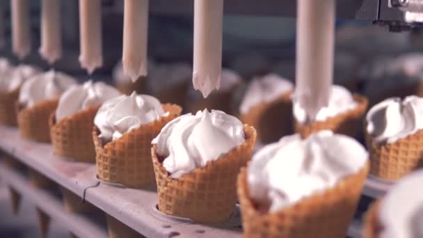 Il gelato viene versato nei coni dei waffle da tubi automatizzati — Video Stock