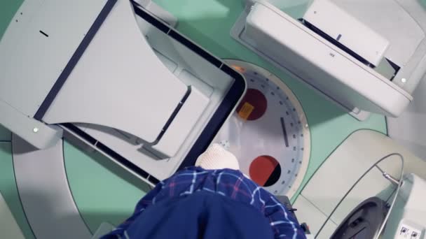 Ακτινοθεραπεία μηχανή σε acrion. Άτομο να πάρει ακτινοβολίας θεραπεία θεραπεία σε μια σύγχρονη κλινική. — Αρχείο Βίντεο