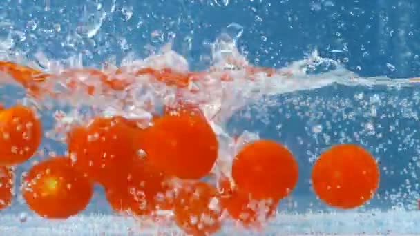 Pomodori a lento movimento che si immergono nell'acqua che sta diventando più veloce in seguito — Video Stock