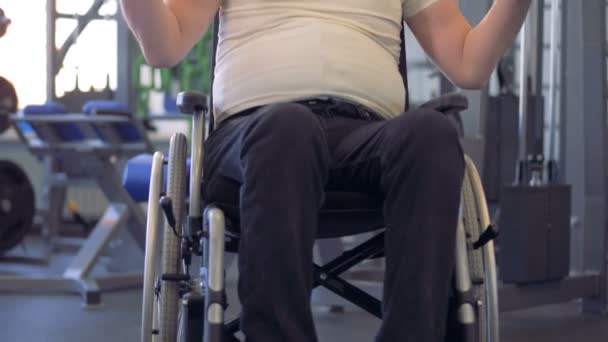 Homme handicapé en fauteuil roulant travaillant avec haltère dans une salle de gym . — Video