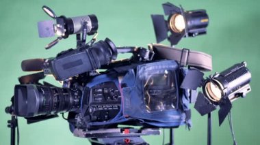 Profesyonel video kamera üzerinde arka plan birkaç aydınlatma bitki ile dönüyor